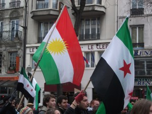 The flag of the Kurdish people, whose rights are largely unrecognized in all four countries of the Middle East where native Kurds can be found, alongside that of the Syrian opposition movement during a March 2013 demonstration in Paris, France.