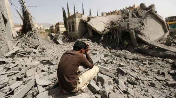 Guard sits on the rubble of the house of Brigadier Fouad al-Emad, an army commander loyal to the Houthis, after air strikes destroyed it in Sanaa, Yemen